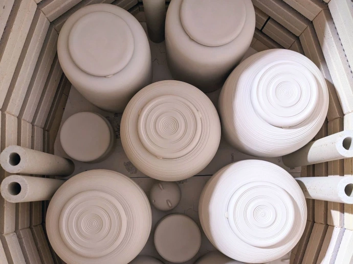 Four ouvert dévoilant le placement des urnes avant la première cuisson du biscuit.